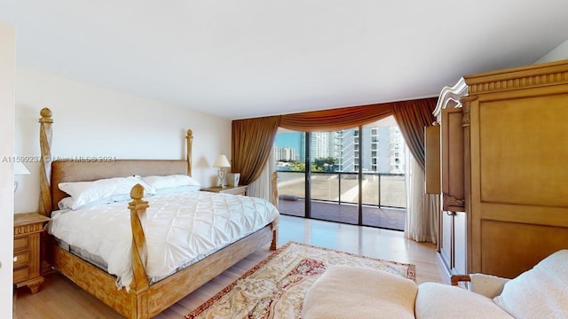 bedroom featuring access to exterior and light wood-type flooring