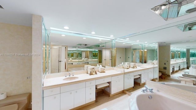 bathroom with a bathing tub, hardwood / wood-style floors, vanity, and toilet