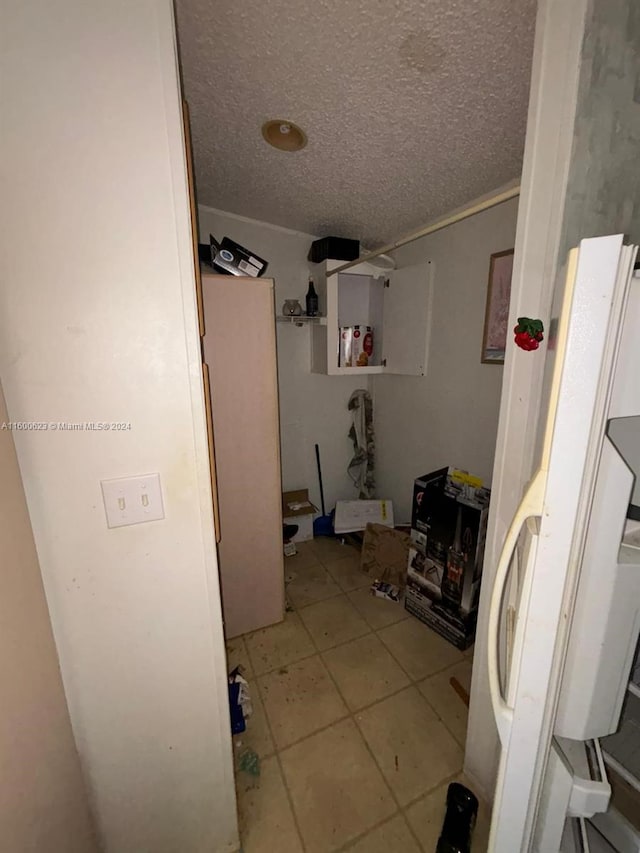 bathroom with a textured ceiling and tile floors