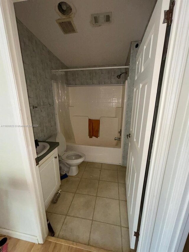 full bathroom with tile flooring, vanity, toilet, and shower / tub combo with curtain