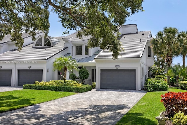 view of front of property featuring a garage and a front lawn