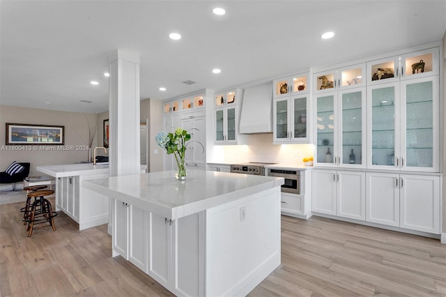 kitchen featuring appliances with stainless steel finishes, white cabinets, and a kitchen island with sink