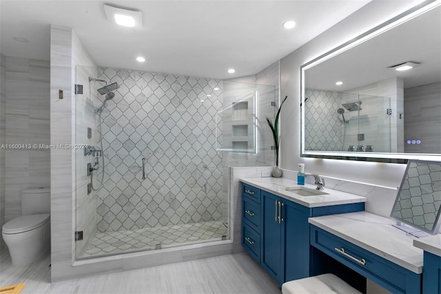 bathroom with vanity, toilet, an enclosed shower, tile walls, and tile patterned flooring