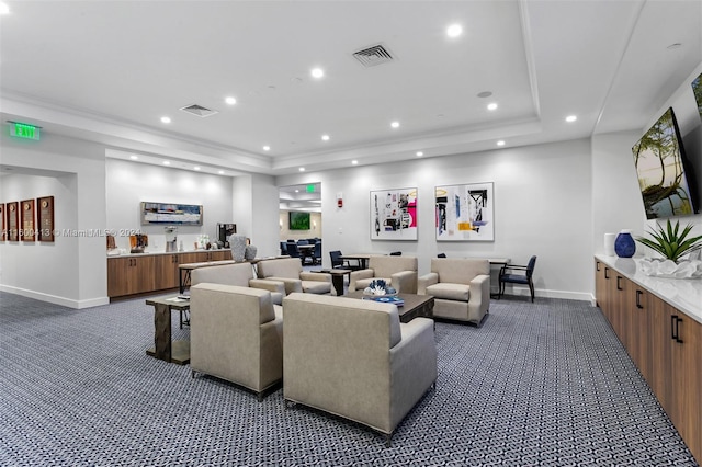 carpeted living room with a tray ceiling