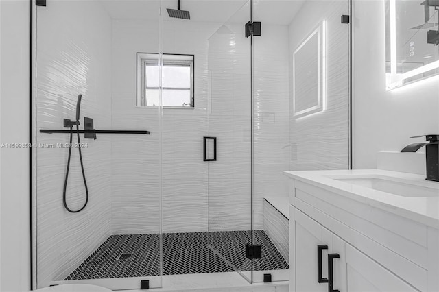 bathroom with a shower with door and vanity