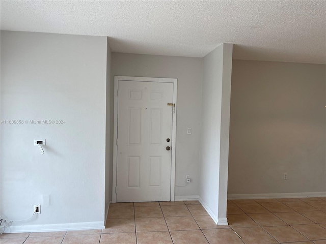 tiled spare room with a textured ceiling