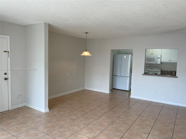 tiled spare room with a textured ceiling