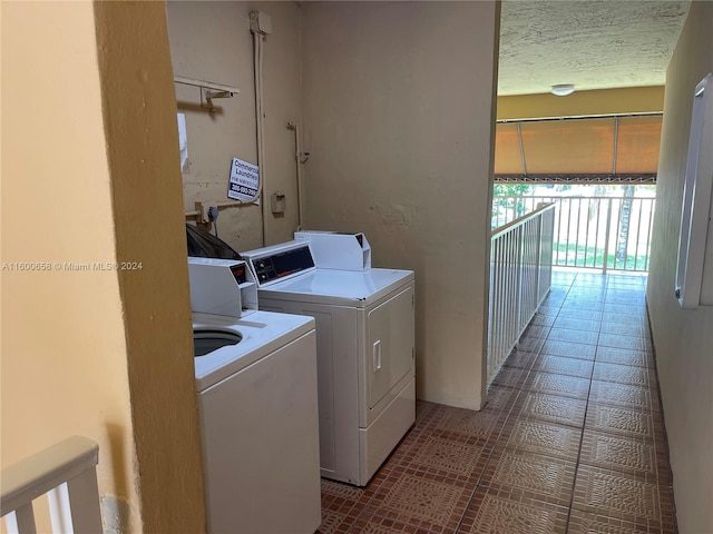 washroom featuring washer and dryer and dark tile floors