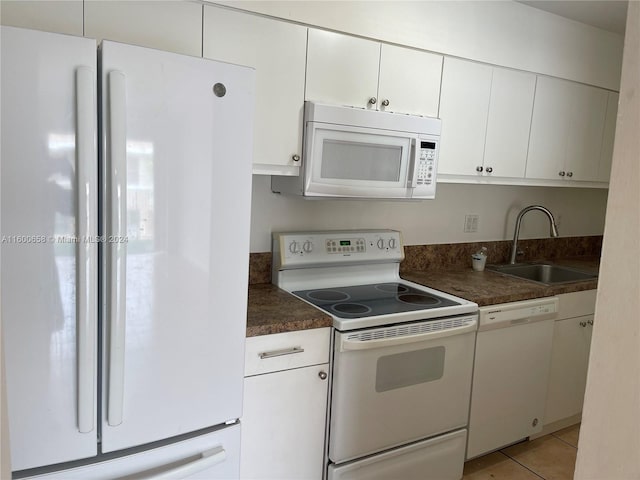 kitchen featuring white appliances, sink, white cabinetry, and light tile floors