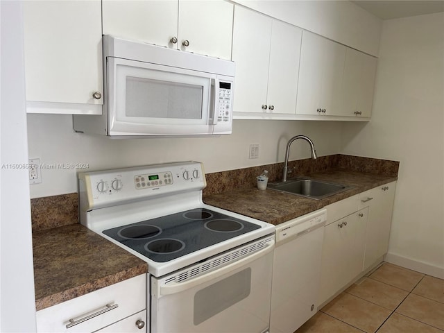 kitchen featuring white appliances, sink, white cabinets, and light tile floors