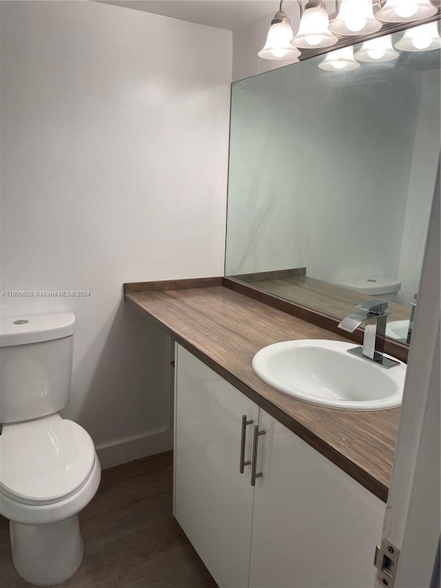 bathroom featuring hardwood / wood-style floors, vanity, and toilet