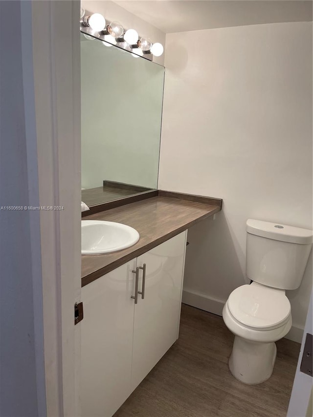 bathroom featuring hardwood / wood-style floors, toilet, and vanity