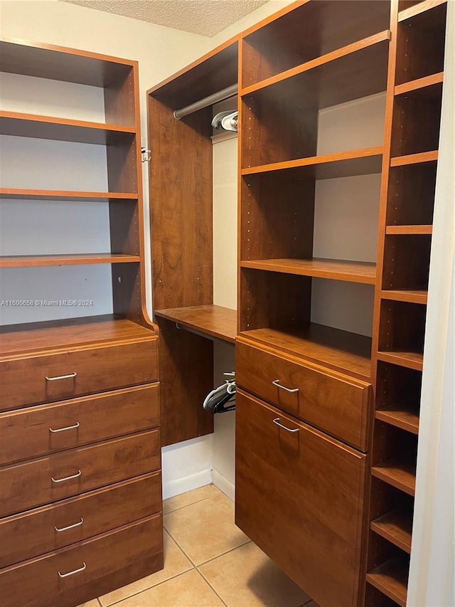 spacious closet with light tile flooring