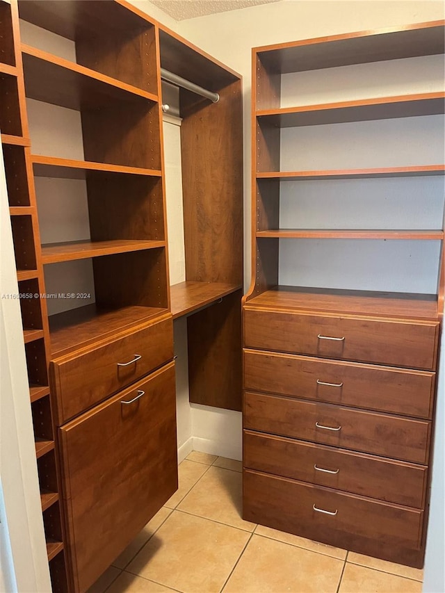 walk in closet featuring light tile floors