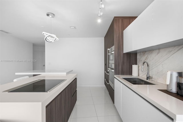 kitchen with pendant lighting, white cabinetry, sink, decorative backsplash, and black electric stovetop