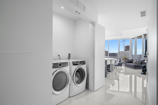 washroom with separate washer and dryer and light tile patterned floors