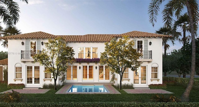 back of house featuring french doors, a yard, and a balcony