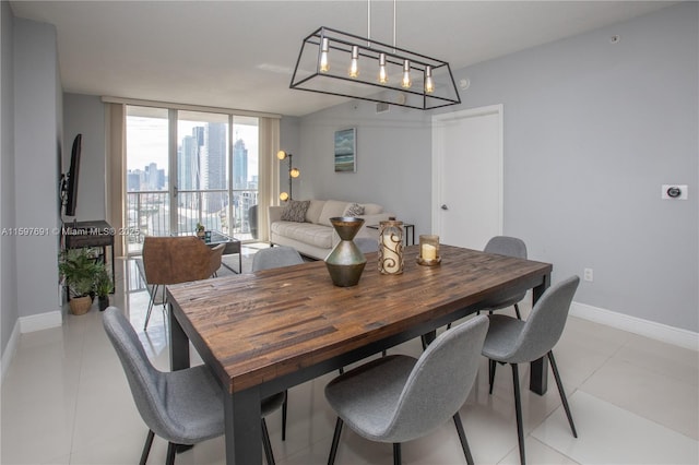 dining area with light tile patterned floors, baseboards, and expansive windows