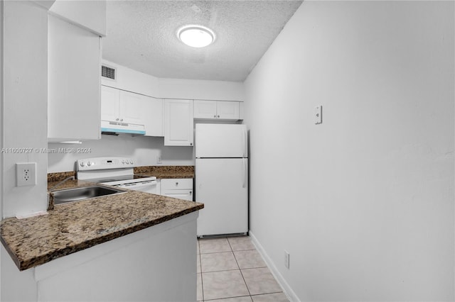 kitchen featuring a textured ceiling, white appliances, sink, light tile patterned floors, and white cabinets