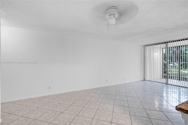 tiled spare room featuring ceiling fan and a textured ceiling