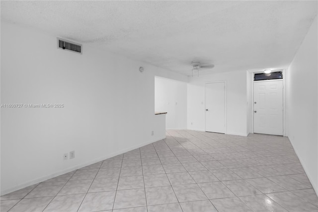 tiled spare room with a textured ceiling