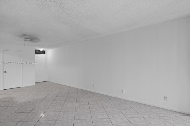 unfurnished room featuring ceiling fan, a textured ceiling, and light tile patterned floors