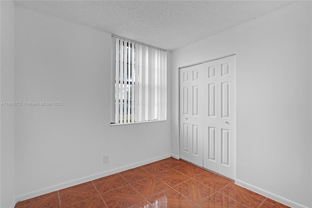 unfurnished room with a textured ceiling