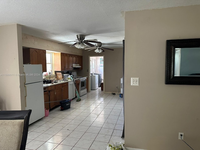 kitchen with white refrigerator, electric stove, ceiling fan, light tile patterned floors, and a textured ceiling