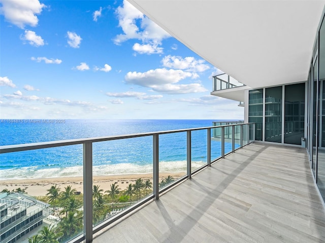 balcony featuring a water view and a view of the beach