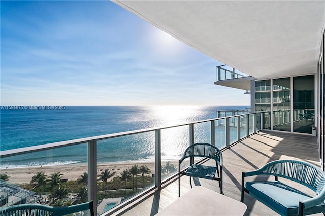 balcony with a water view and a beach view