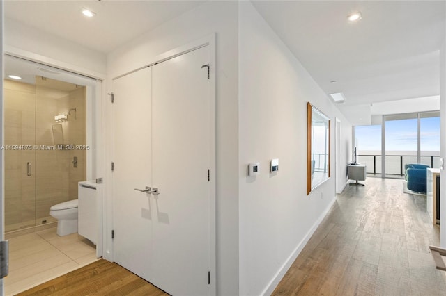 corridor with recessed lighting, baseboards, and wood finished floors