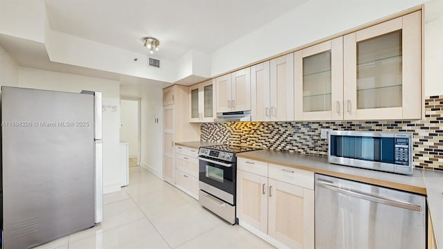 kitchen featuring decorative backsplash, light tile patterned floors, and stainless steel appliances