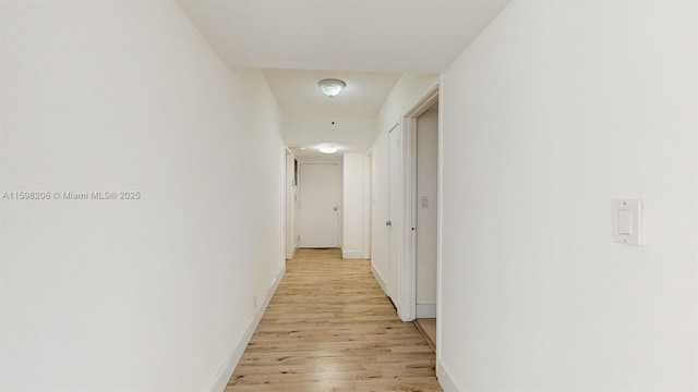 hallway with light hardwood / wood-style floors