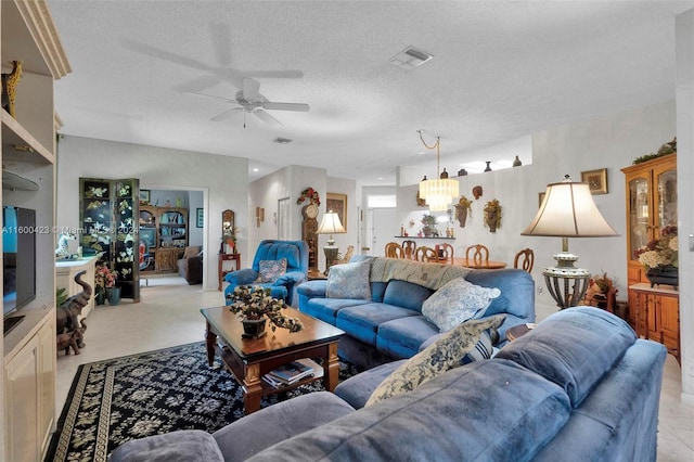 living room with ceiling fan with notable chandelier and a textured ceiling