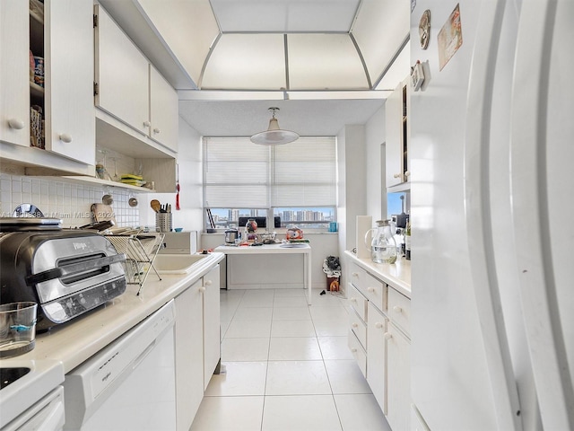 kitchen with white cabinets, white appliances, backsplash, and light tile patterned floors