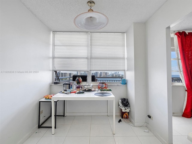 interior space featuring light tile patterned floors and a textured ceiling