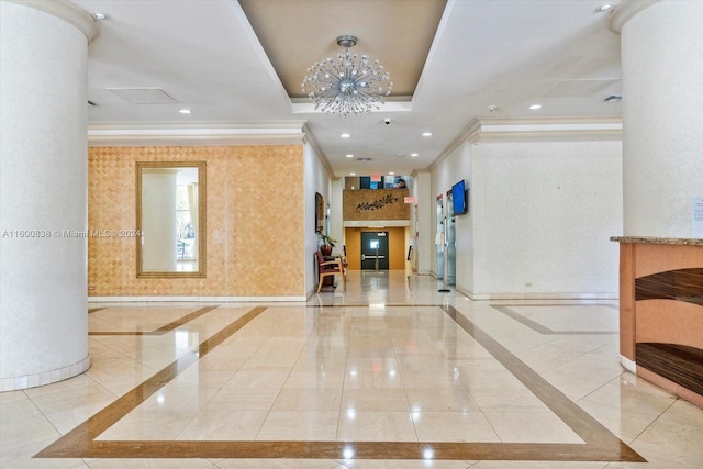 interior space featuring a raised ceiling, a notable chandelier, and ornamental molding