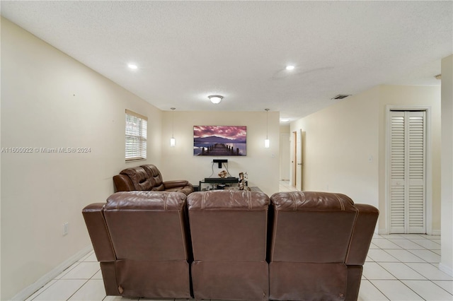 living room with a textured ceiling and light tile floors