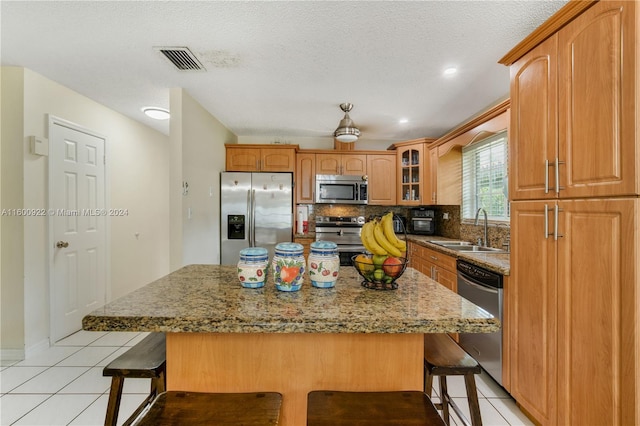 kitchen with sink, tasteful backsplash, a kitchen bar, and appliances with stainless steel finishes