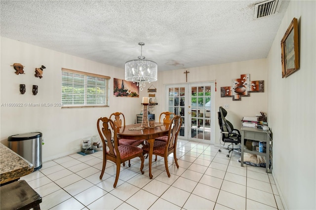 dining space with a notable chandelier, a healthy amount of sunlight, light tile flooring, and french doors