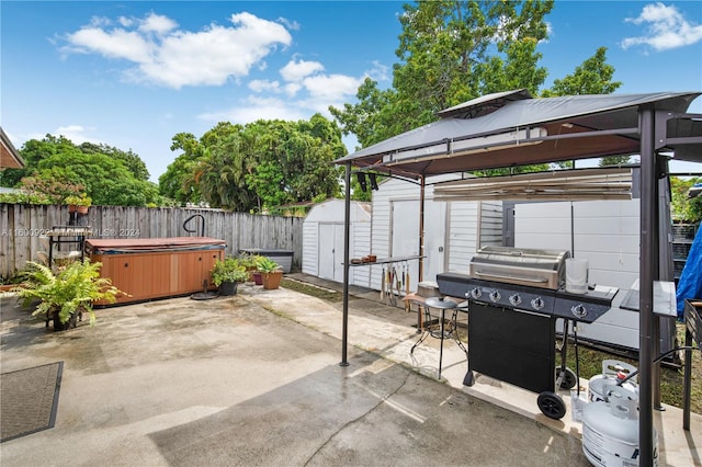 view of terrace featuring a grill, a hot tub, a shed, and a gazebo