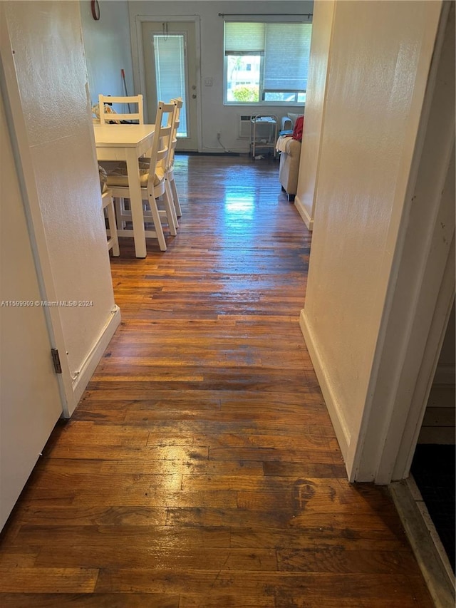 hall with baseboards and wood finished floors