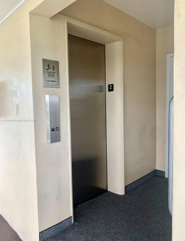 corridor with carpet flooring and elevator