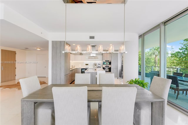 dining area with a wall of windows and light tile flooring