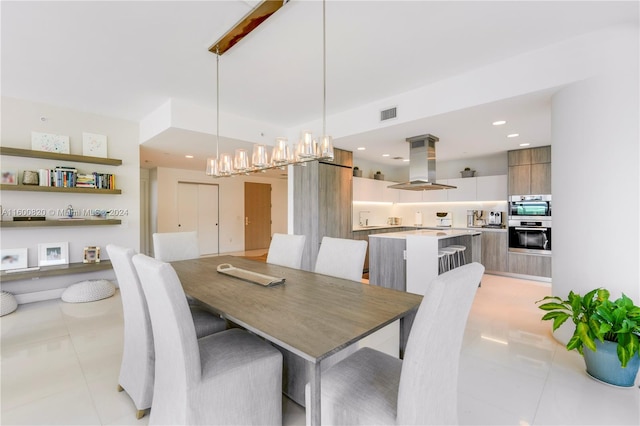 dining room with a chandelier and light tile floors