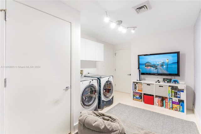 washroom with separate washer and dryer, washer hookup, rail lighting, and cabinets