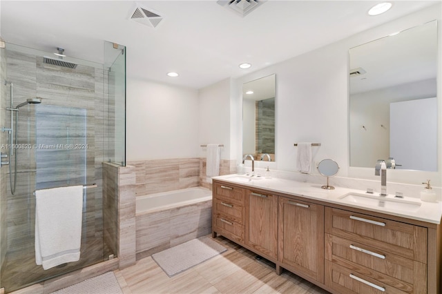 bathroom with dual bowl vanity, tile flooring, and independent shower and bath