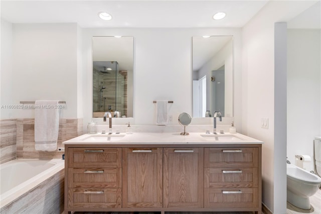 bathroom with a bidet, dual sinks, oversized vanity, and independent shower and bath