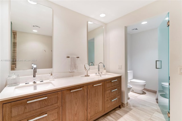 bathroom featuring tile floors, a bidet, toilet, and dual bowl vanity