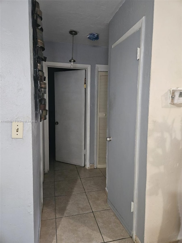 hall with tile patterned floors